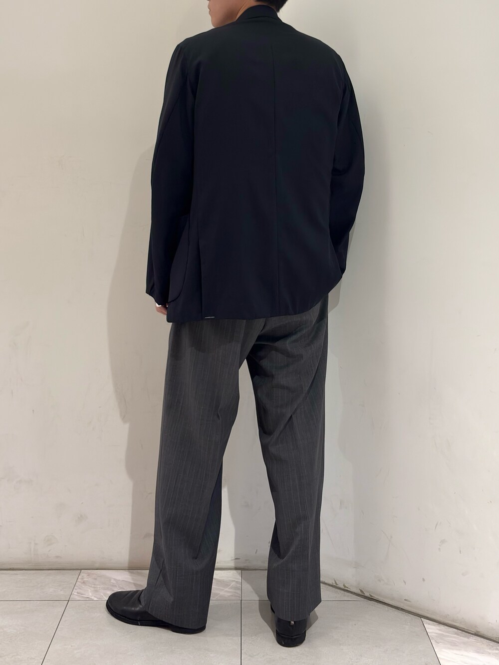 ブラック系のブーツ、グレー系のその他パンツ、ブルー系のニット/セーターを着用したメンズの春コーディネートの6枚目の写真