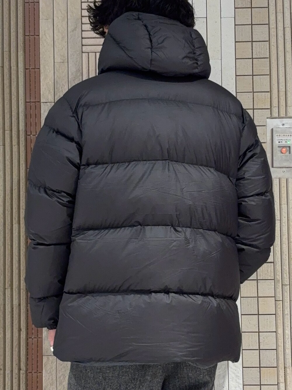 グリーン系のダウンジャケット/コート、ブラック系のニット/セーター、グレー系のその他パンツを着用したメンズの冬コーディネートの8枚目の写真