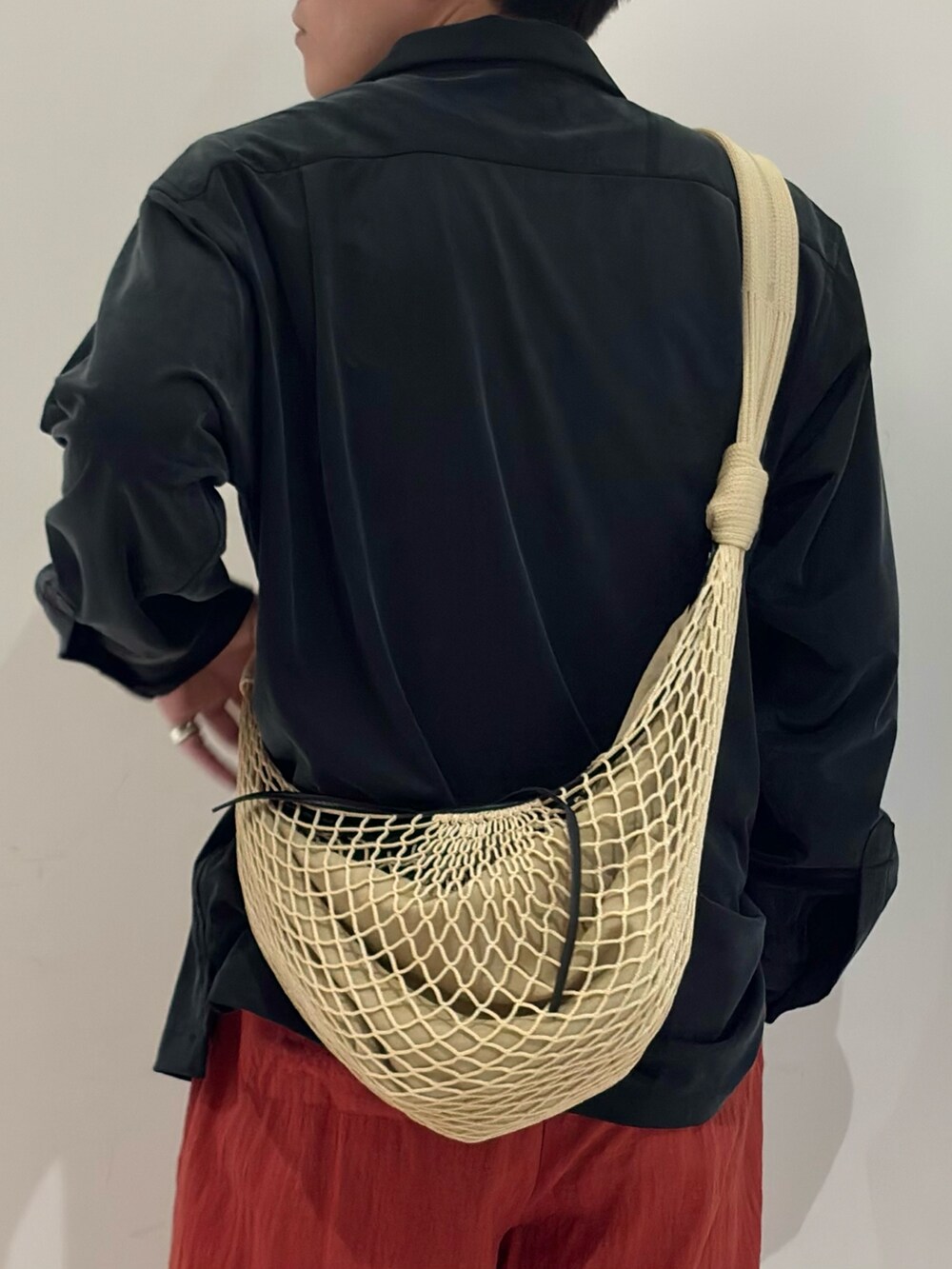 ブラック系のシャツ/ブラウス、ベージュ系のショルダーバッグ、ブラック系のブーツを着用したメンズの春コーディネートの7枚目の写真