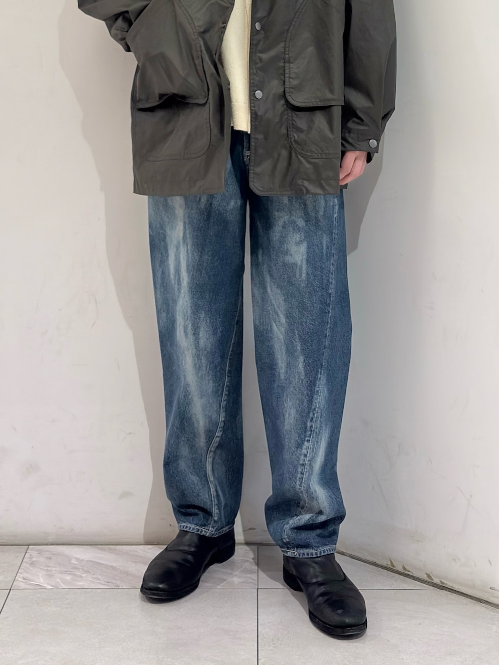 グリーン系のその他アウター、イエロー系のニット/セーター、ブルー系のデニムパンツを着用したメンズの春コーディネートの3枚目の写真