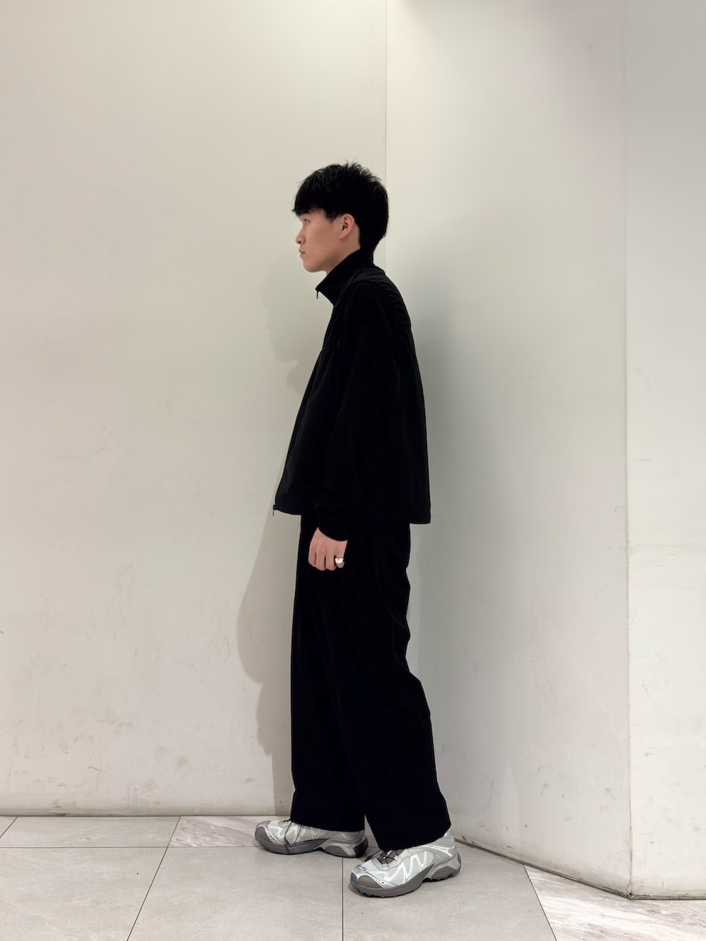 ブラック系のTシャツ/カットソー、ブラック系のその他パンツ、シルバー系のスニーカーを着用したメンズの春コーディネートの4枚目の写真