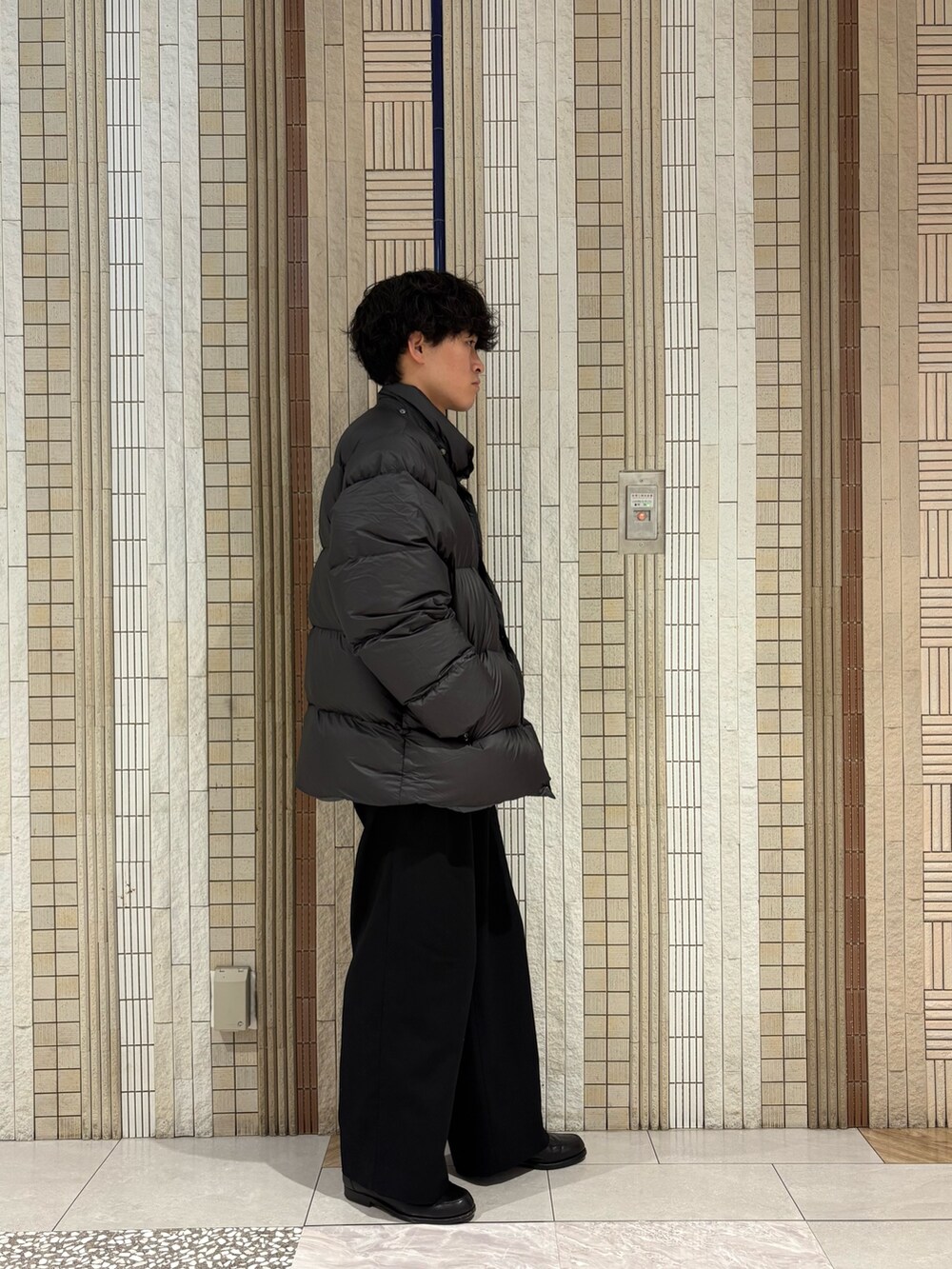 グリーン系のダウンジャケット/コート、グレー系のニット/セーターを着用したメンズの冬コーディネートの5枚目の写真