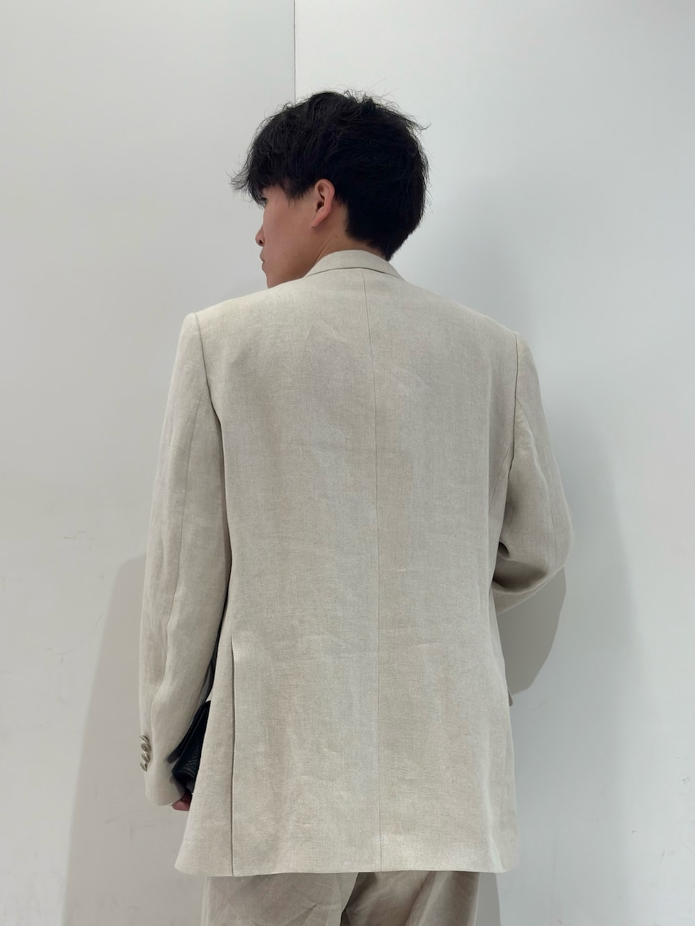 ブラウン系のニット/セーター、ベージュ系のその他パンツ、ブラック系のブーツを着用したメンズの春コーディネートの5枚目の写真