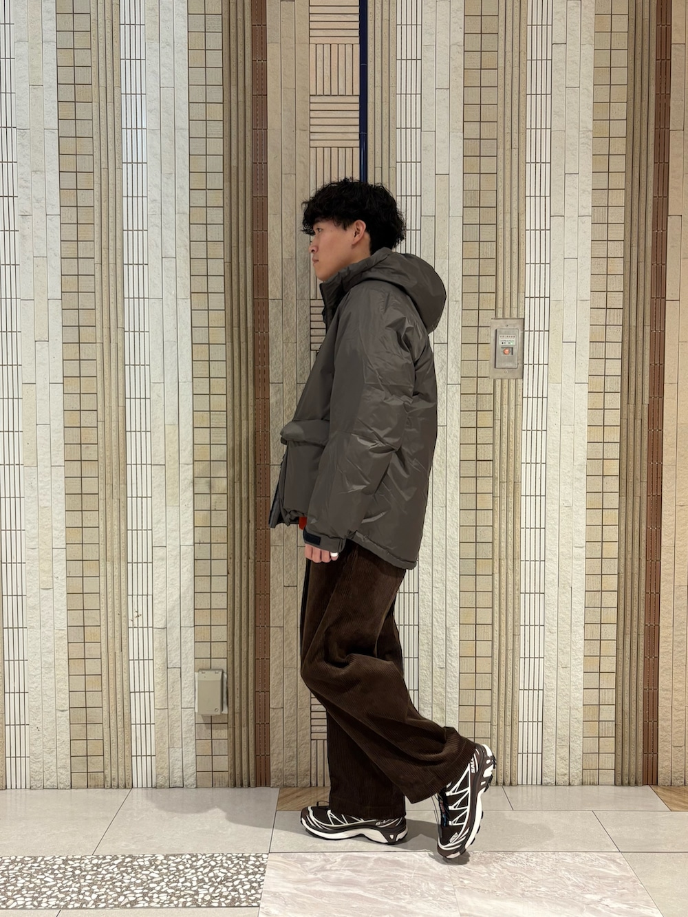 グレー系のダウンジャケット/コート、レッド系のニット/セーター、ブラウン系のその他パンツを着用したメンズの秋コーディネートの5枚目の写真