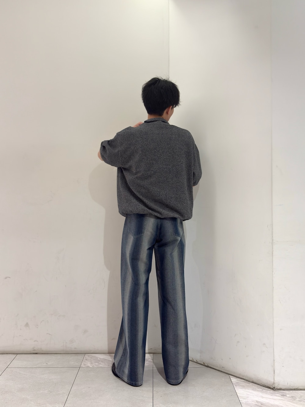 グレー系のニット/セーター、ブルー系のデニムパンツ、ブラック系のブーツを着用したメンズの春コーディネートの5枚目の写真
