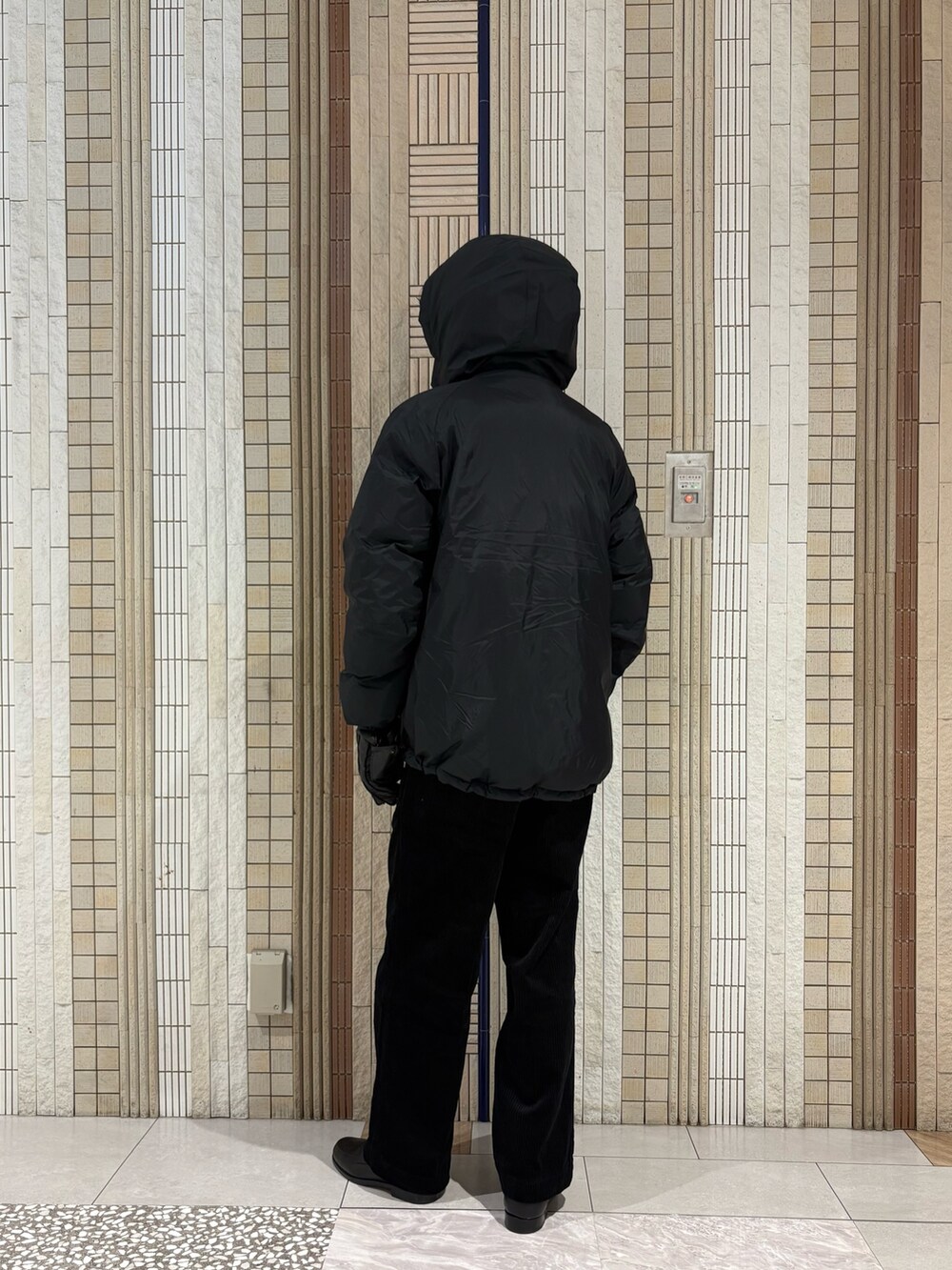 ブラック系のダウンジャケット/コート、グレー系のニット/セーター、ブラック系のその他パンツを着用したメンズの秋コーディネートの9枚目の写真