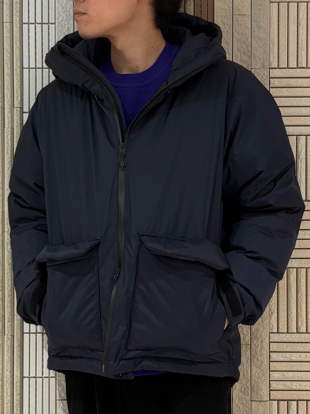 ブルー系のダウンジャケット/コート、パープル系のニット/セーター、ブルー系のその他パンツを着用したメンズの秋コーディネートの3枚目の写真