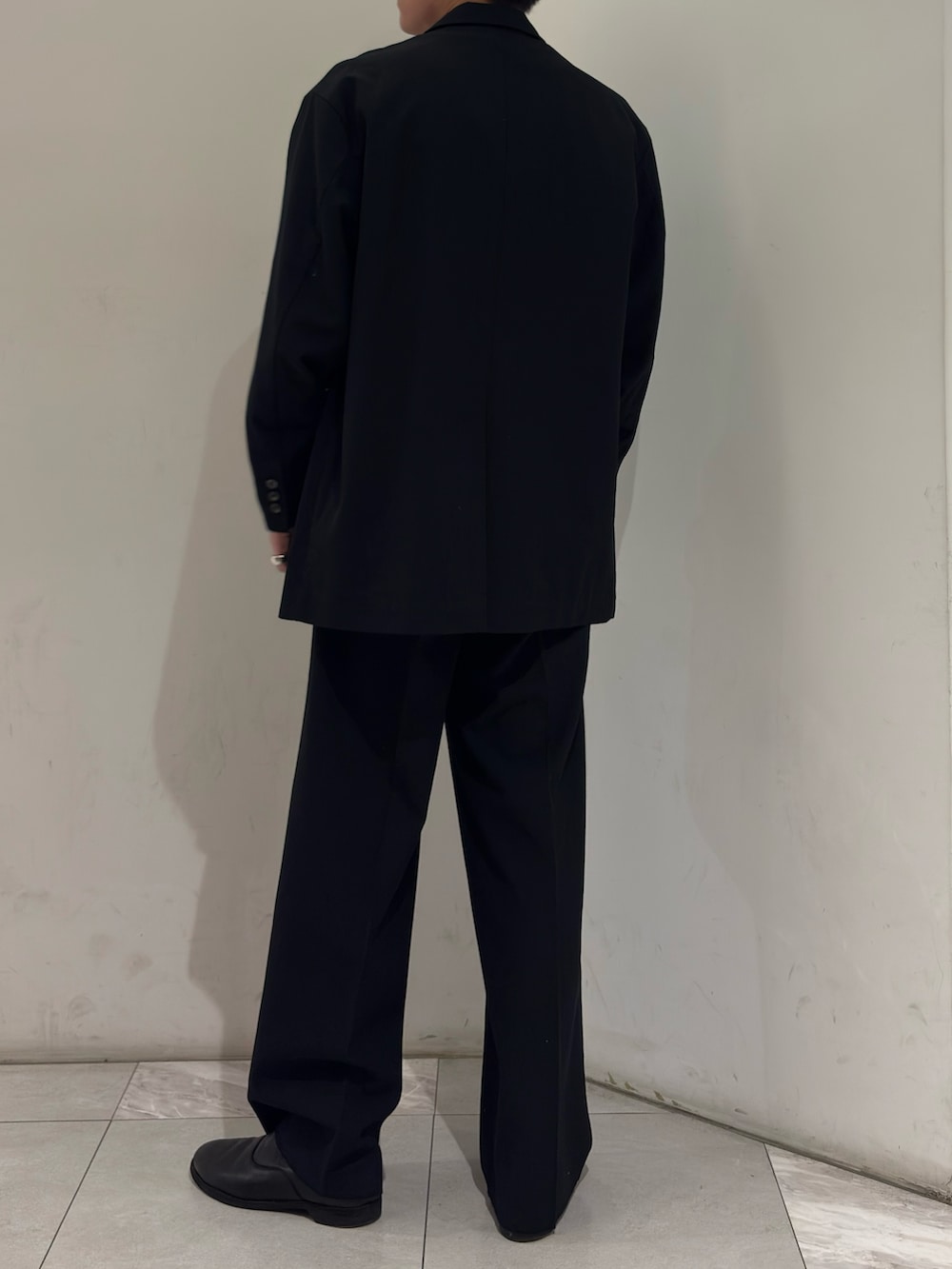 ブラック系のその他アウター、イエロー系のニット/セーター、ブラック系のその他パンツを着用したメンズの春コーディネートの6枚目の写真