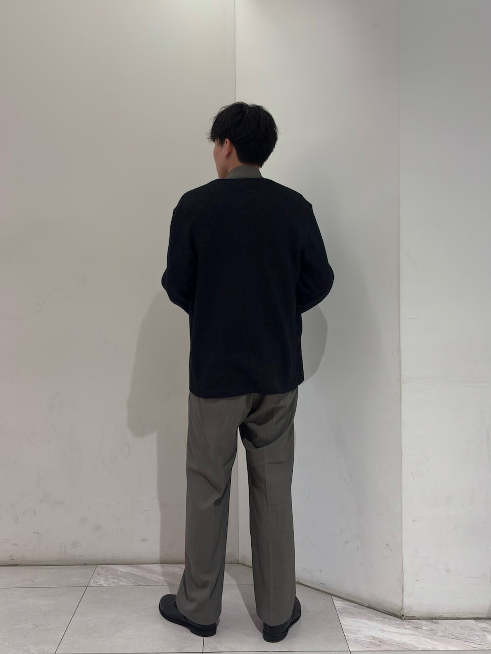 ブラック系のニット/セーター、ブラック系のベスト、グレー系のブルゾンを着用したメンズの春コーディネートの5枚目の写真