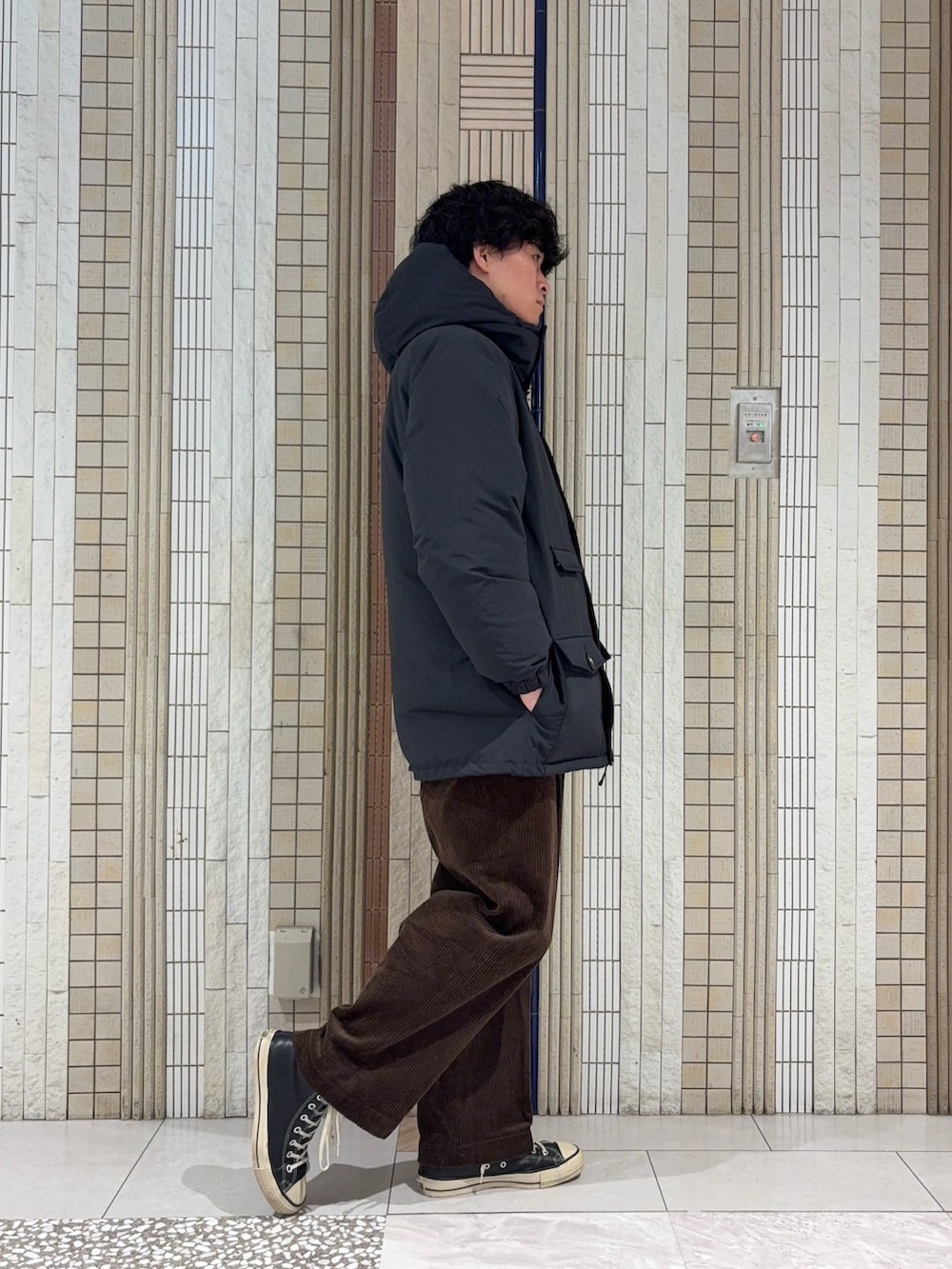 ブラック系のダウンジャケット/コート、ブラック系のニット/セーター、ブラウン系のその他パンツを着用したメンズの冬コーディネートの7枚目の写真