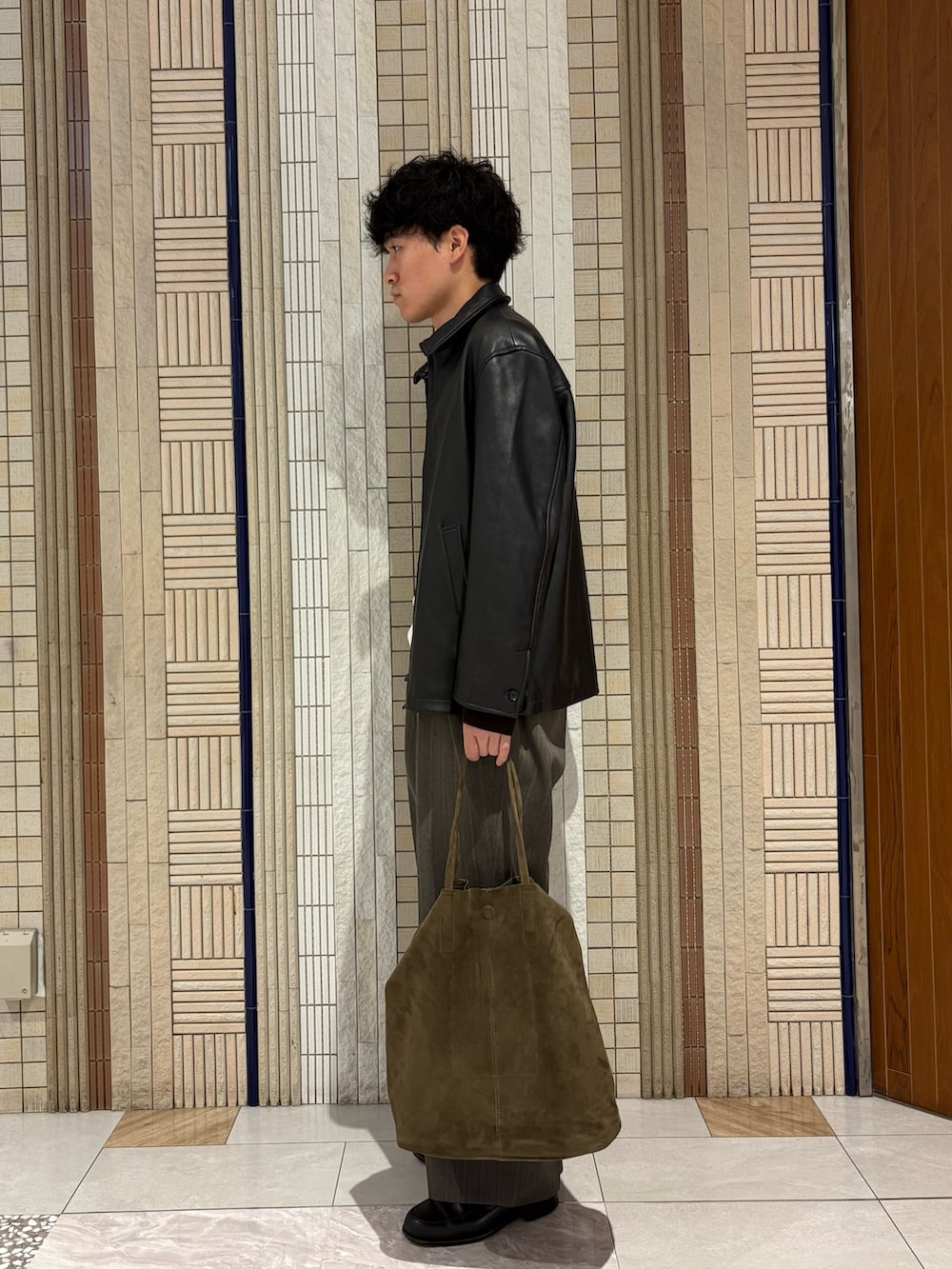 ブラウン系のニット/セーター、ブラック系のその他アウター、グレー系のその他パンツを着用したメンズの秋コーディネートの3枚目の写真