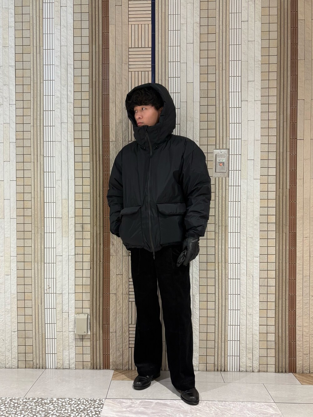 ブラック系のダウンジャケット/コート、グレー系のニット/セーター、ブラック系のその他パンツを着用したメンズの秋コーディネートの2枚目の写真