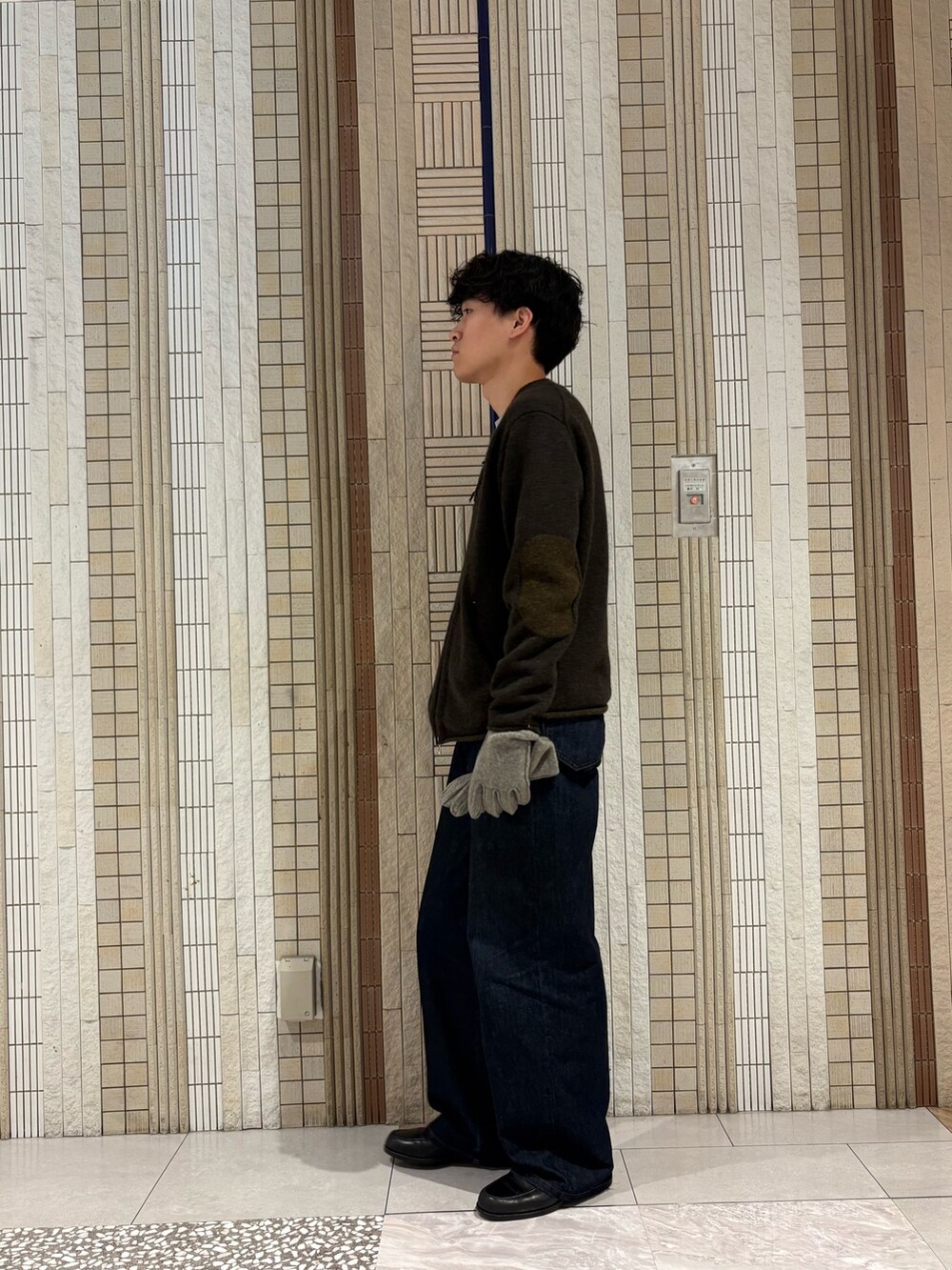 グレー系のニット/セーター、グレー系の手袋を着用したメンズの秋コーディネートの7枚目の写真