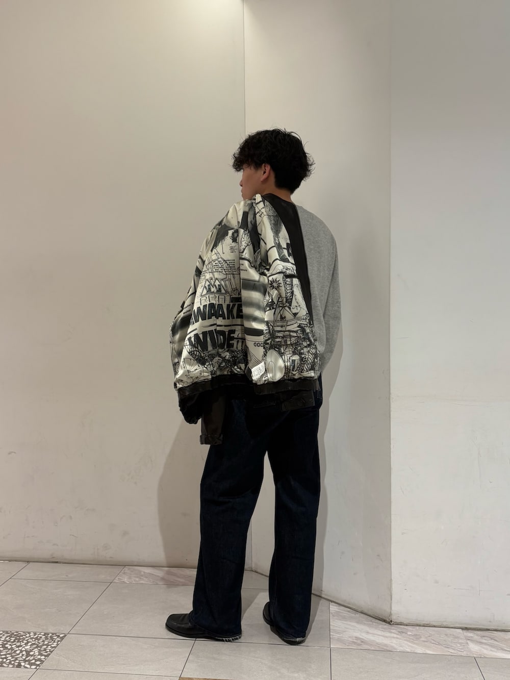 ブラック系のテーラードジャケット、ブラウン系の手袋を着用したメンズの冬コーディネートの9枚目の写真