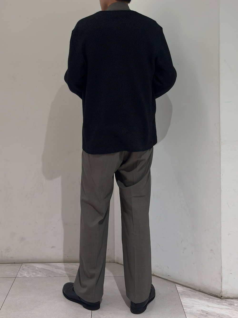 ブラック系のニット/セーター、ブラック系のベスト、グレー系のブルゾンを着用したメンズの春コーディネートの6枚目の写真