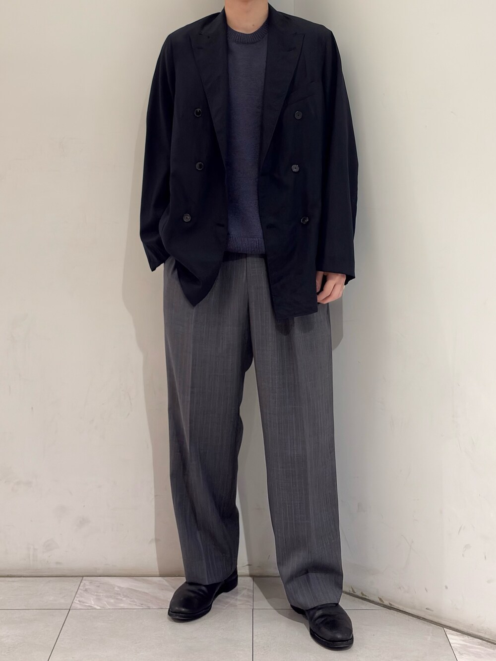 ブラック系のブーツ、グレー系のその他パンツ、ブルー系のニット/セーターを着用したメンズの春コーディネートの3枚目の写真