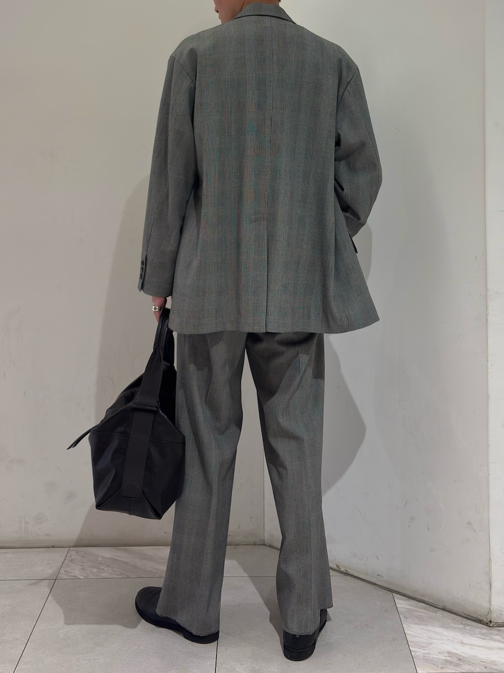 イエロー系のニット/セーター、ブラック系のブーツを着用したメンズの春コーディネートの6枚目の写真