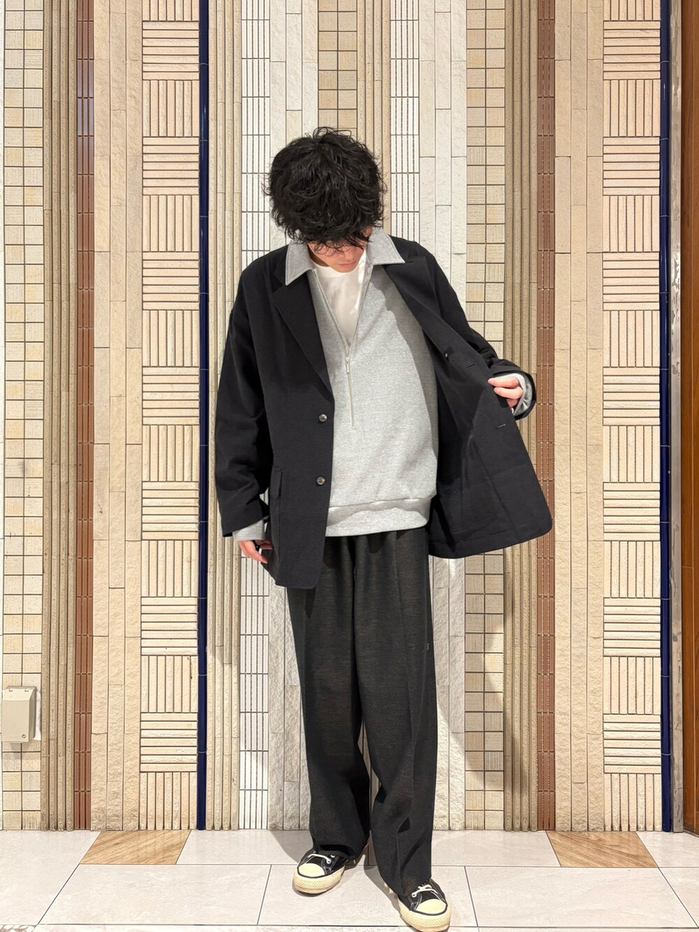 グレー系のTシャツ/カットソー、ブラック系のテーラードジャケットを着用したメンズの秋コーディネートの4枚目の写真