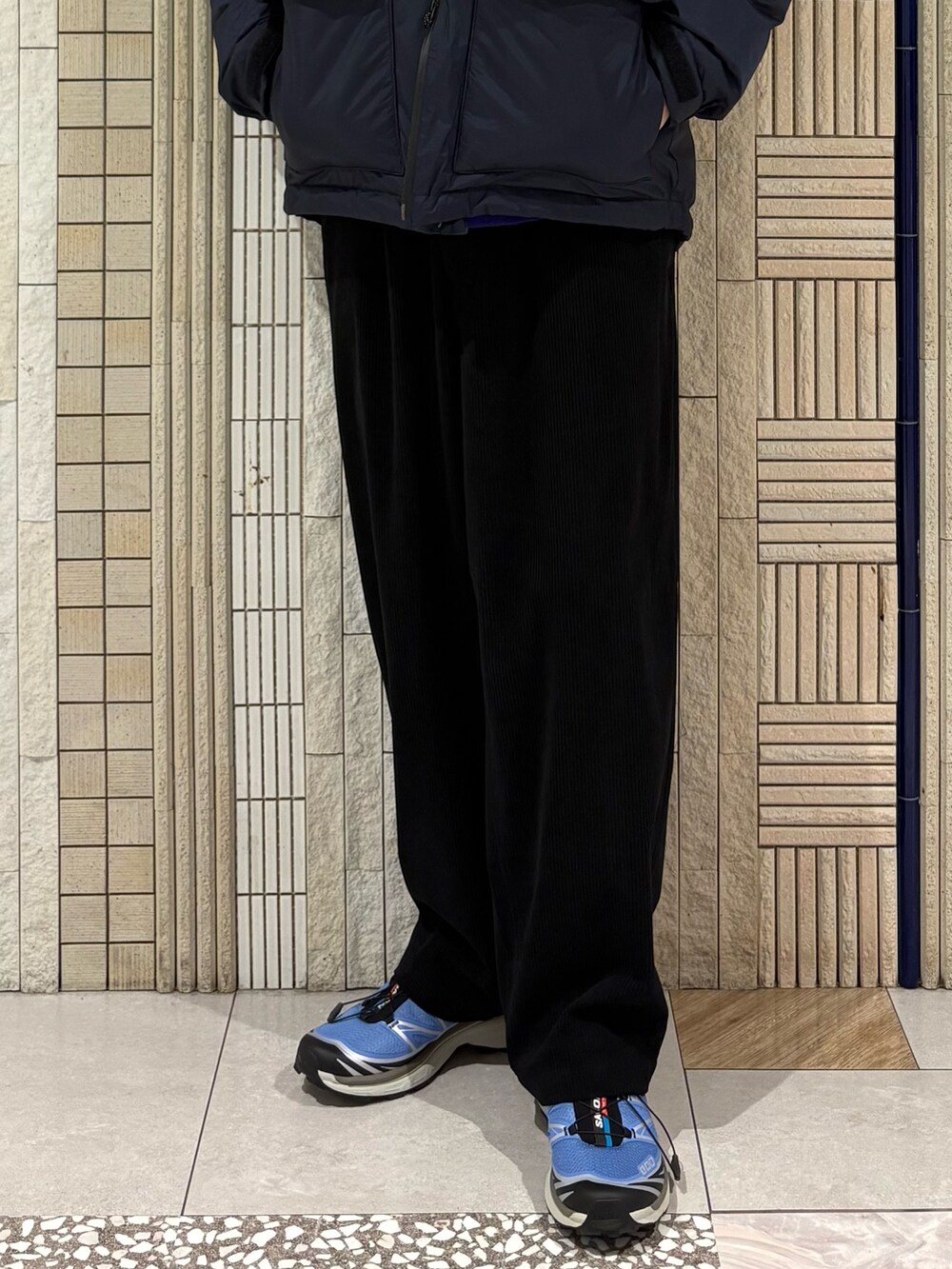 ブルー系のダウンジャケット/コート、パープル系のニット/セーター、ブルー系のその他パンツを着用したメンズの秋コーディネートの4枚目の写真