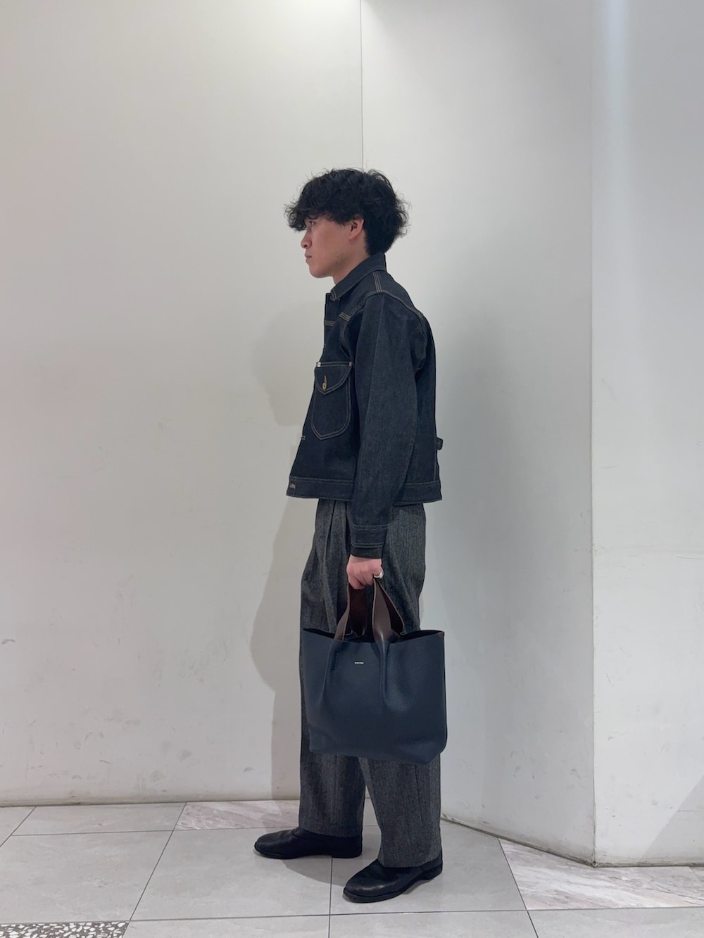 ブルー系のデニムジャケット、ブラック系のシャツ/ブラウス、グレー系のその他パンツを着用したメンズの冬コーディネートの4枚目の写真