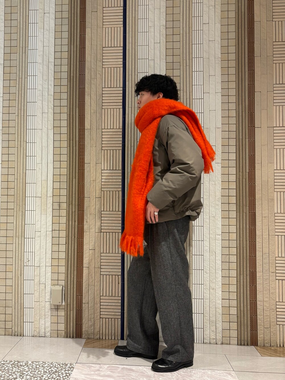 ベージュ系のダウンジャケット/コート、ブラウン系のニット/セーター、グレー系のその他パンツを着用したメンズの秋コーディネートの6枚目の写真