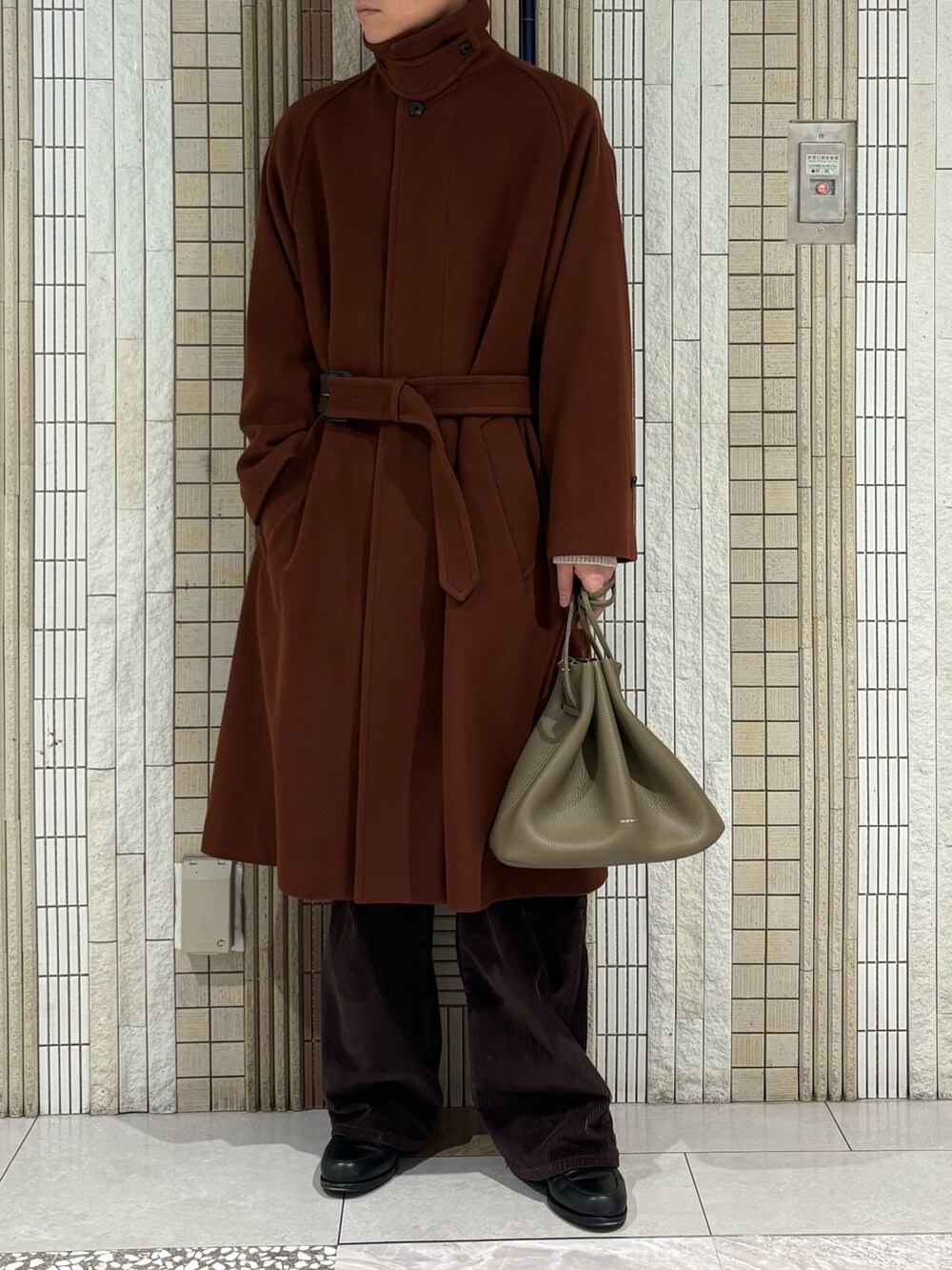 ブラウン系のステンカラーコート、ホワイト系のニット/セーター、ベージュ系のその他雑貨を着用したメンズの冬コーディネートの4枚目の写真