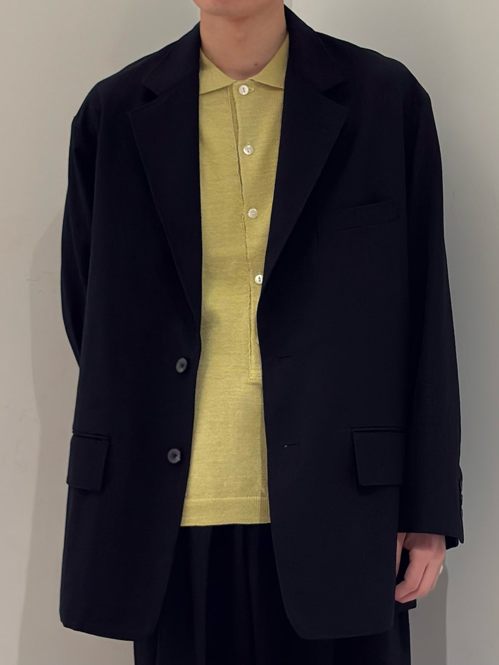 ブラック系のその他アウター、イエロー系のニット/セーター、ブラック系のその他パンツを着用したメンズの春コーディネートの3枚目の写真