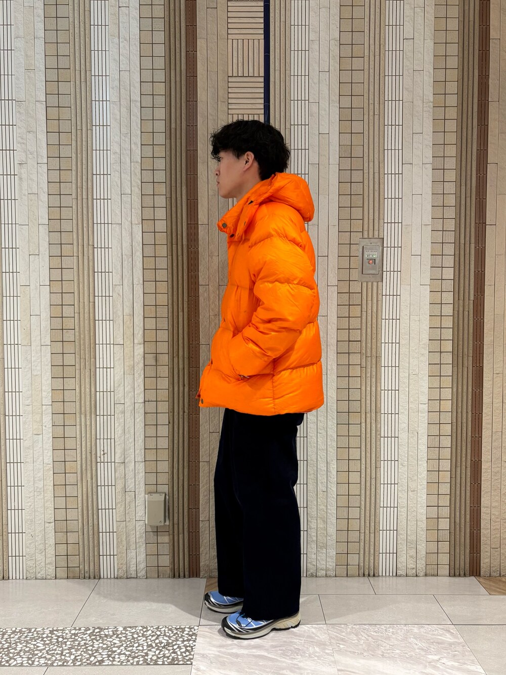 ブルー系のその他パンツ、ブルー系のスニーカー、オレンジ系のダウンジャケット/コートを着用したメンズの秋コーディネートの7枚目の写真