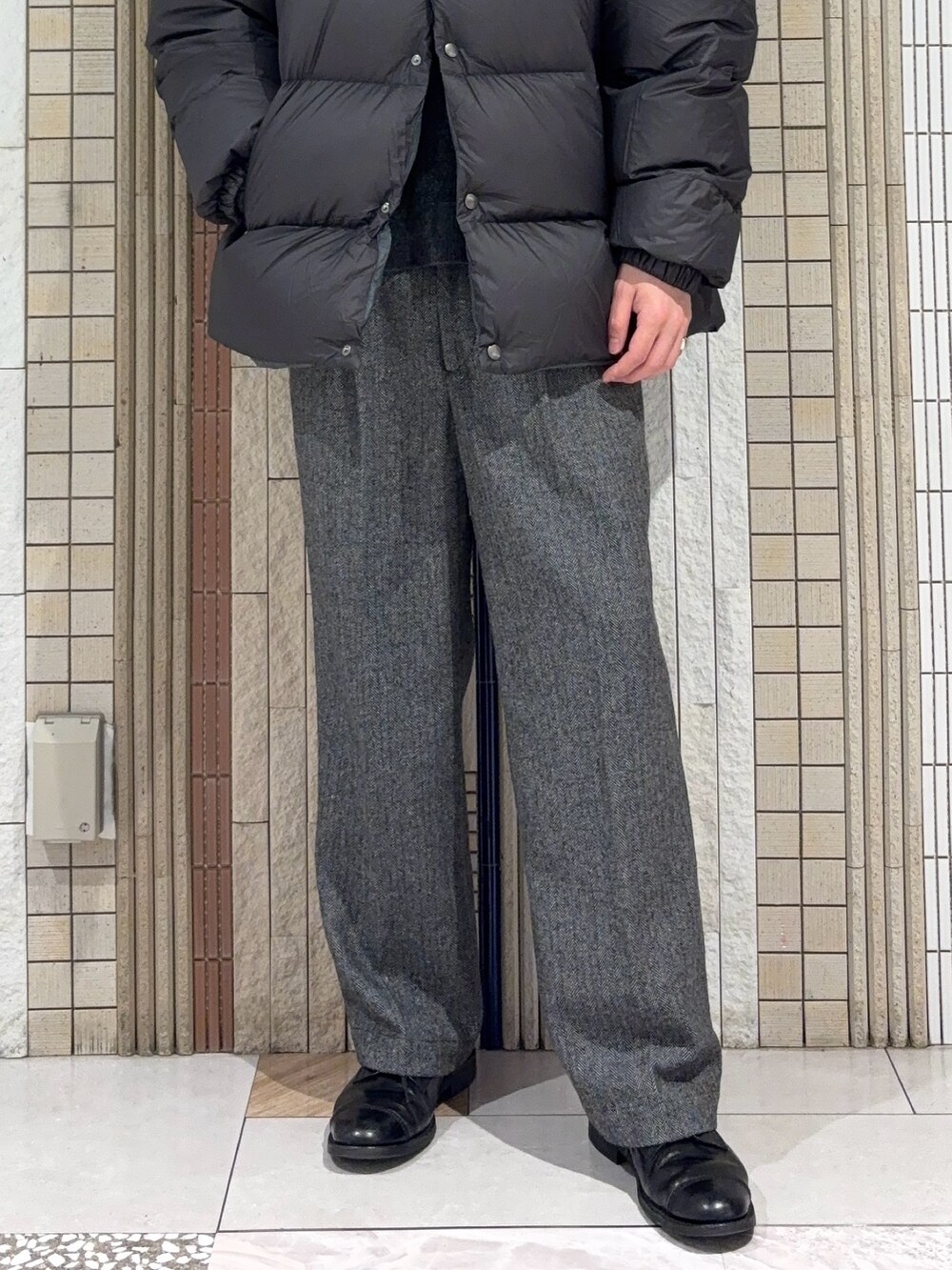 グリーン系のダウンジャケット/コート、ブラック系のニット/セーター、グレー系のその他パンツを着用したメンズの冬コーディネートの5枚目の写真