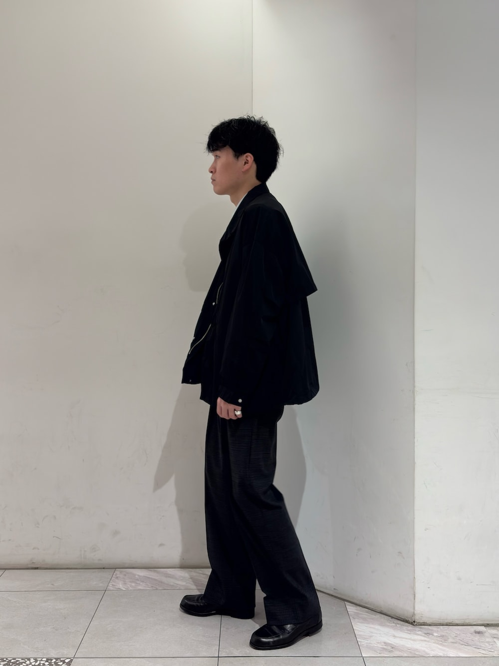 ブラック系のナイロンジャケット、グレー系のその他パンツを着用したメンズの春コーディネートの4枚目の写真