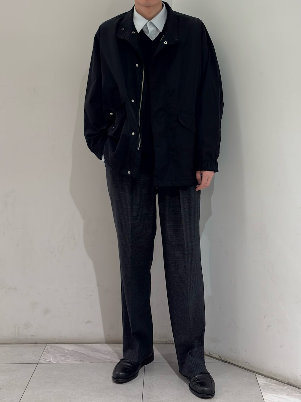 ブラック系のナイロンジャケット、グレー系のその他パンツを着用したメンズの春コーディネートの2枚目の写真