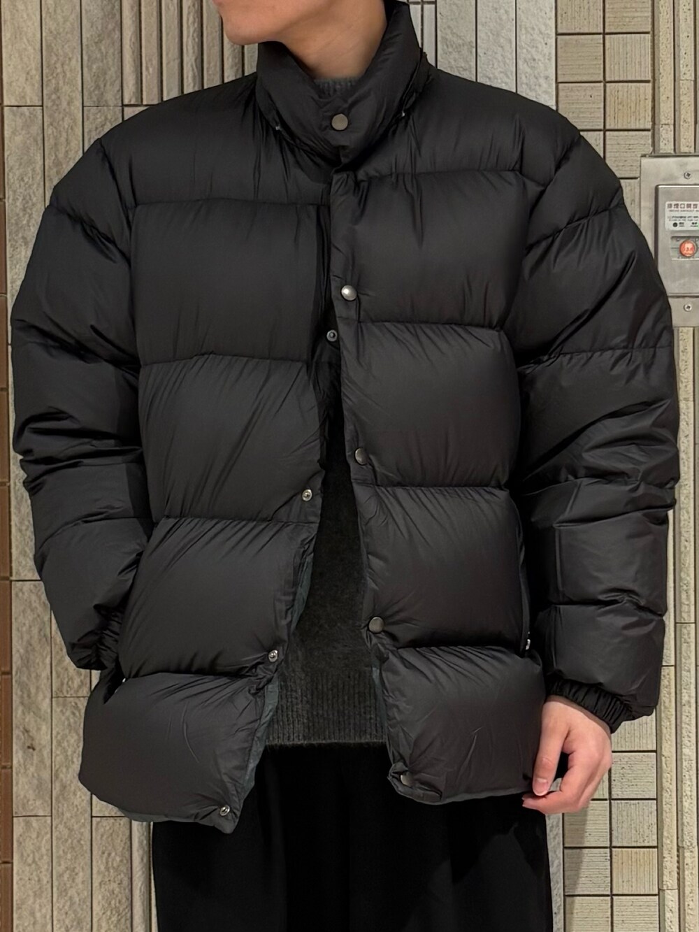 グリーン系のダウンジャケット/コート、グレー系のニット/セーターを着用したメンズの冬コーディネートの4枚目の写真