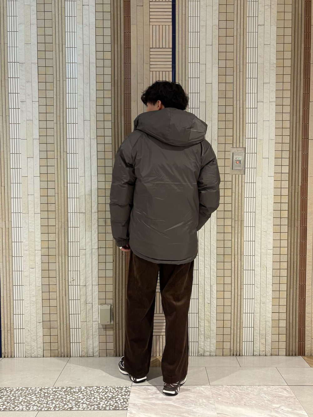 グレー系のダウンジャケット/コート、レッド系のニット/セーター、ブラウン系のその他パンツを着用したメンズの秋コーディネートの7枚目の写真