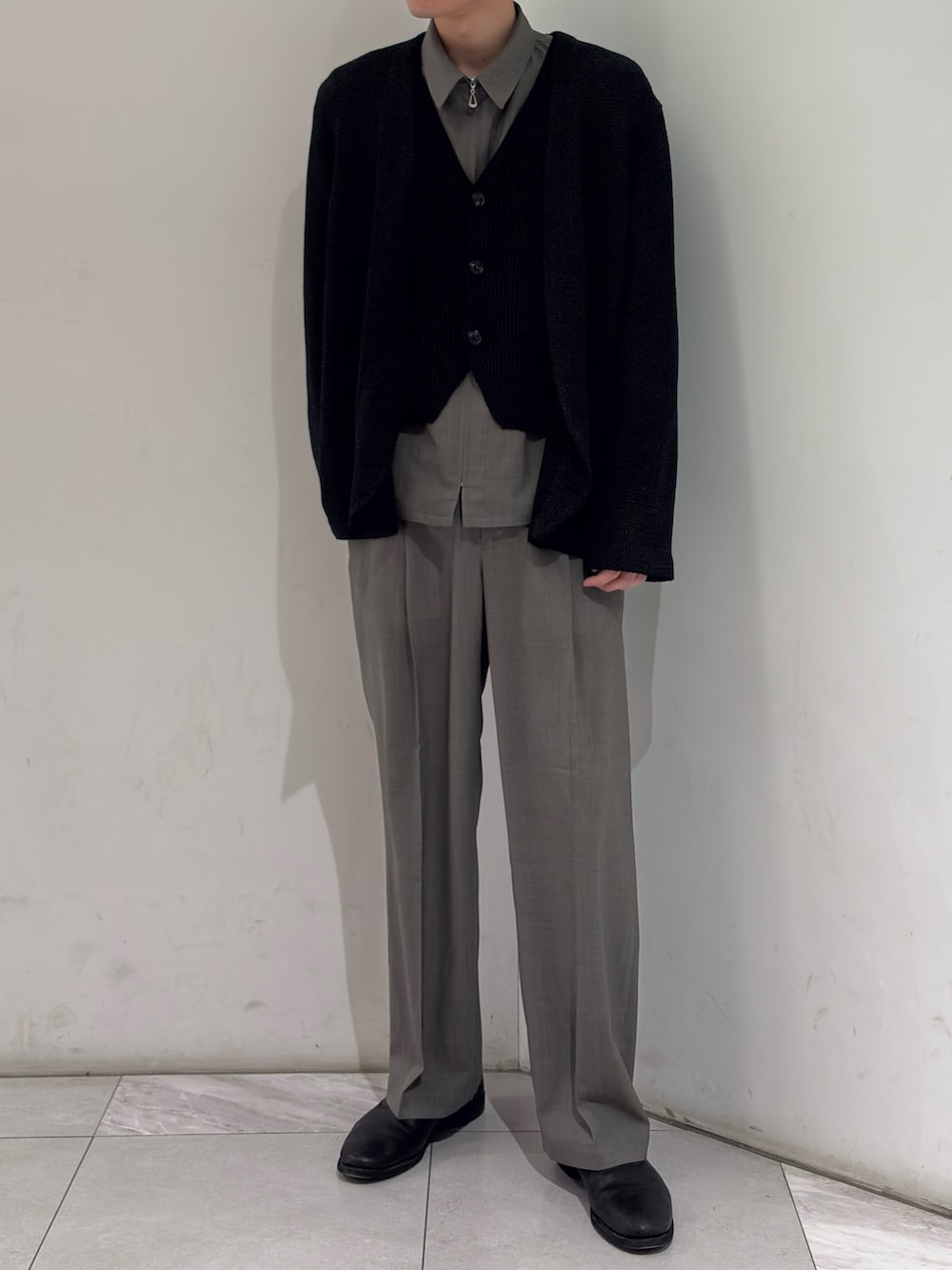 ブラック系のニット/セーター、ブラック系のベスト、グレー系のブルゾンを着用したメンズの春コーディネートの2枚目の写真