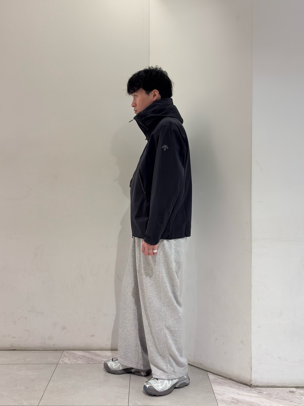 ブラック系のテーラードジャケット、グレー系のその他パンツ、シルバー系のスニーカーを着用したメンズの春コーディネートの4枚目の写真