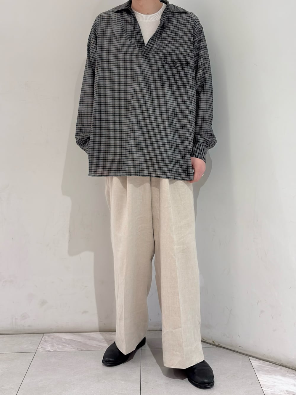 ブラック系のシャツ/ブラウス、ベージュ系のその他パンツ、ブラック系のブーツを着用したメンズの春コーディネートの2枚目の写真