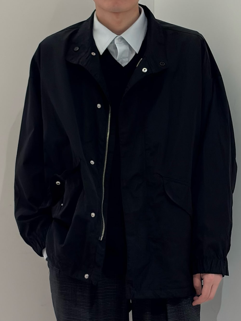 ブラック系のナイロンジャケット、グレー系のその他パンツを着用したメンズの春コーディネートの3枚目の写真