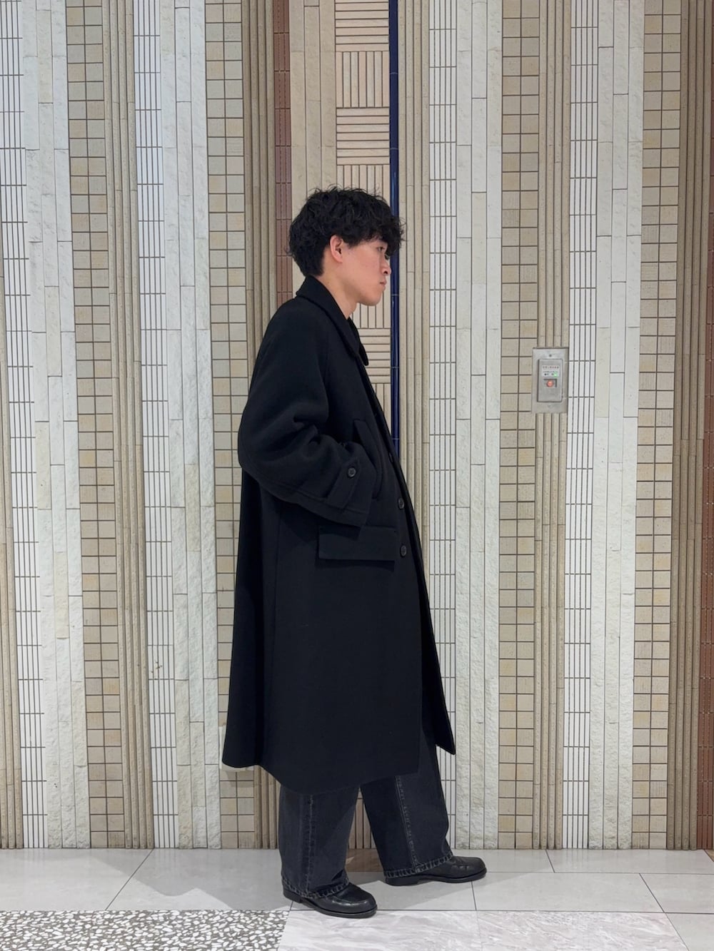 ブラック系のその他アウター、ブラック系のニット/セーター、ブラック系のデニムパンツを着用したメンズの秋コーディネートの6枚目の写真