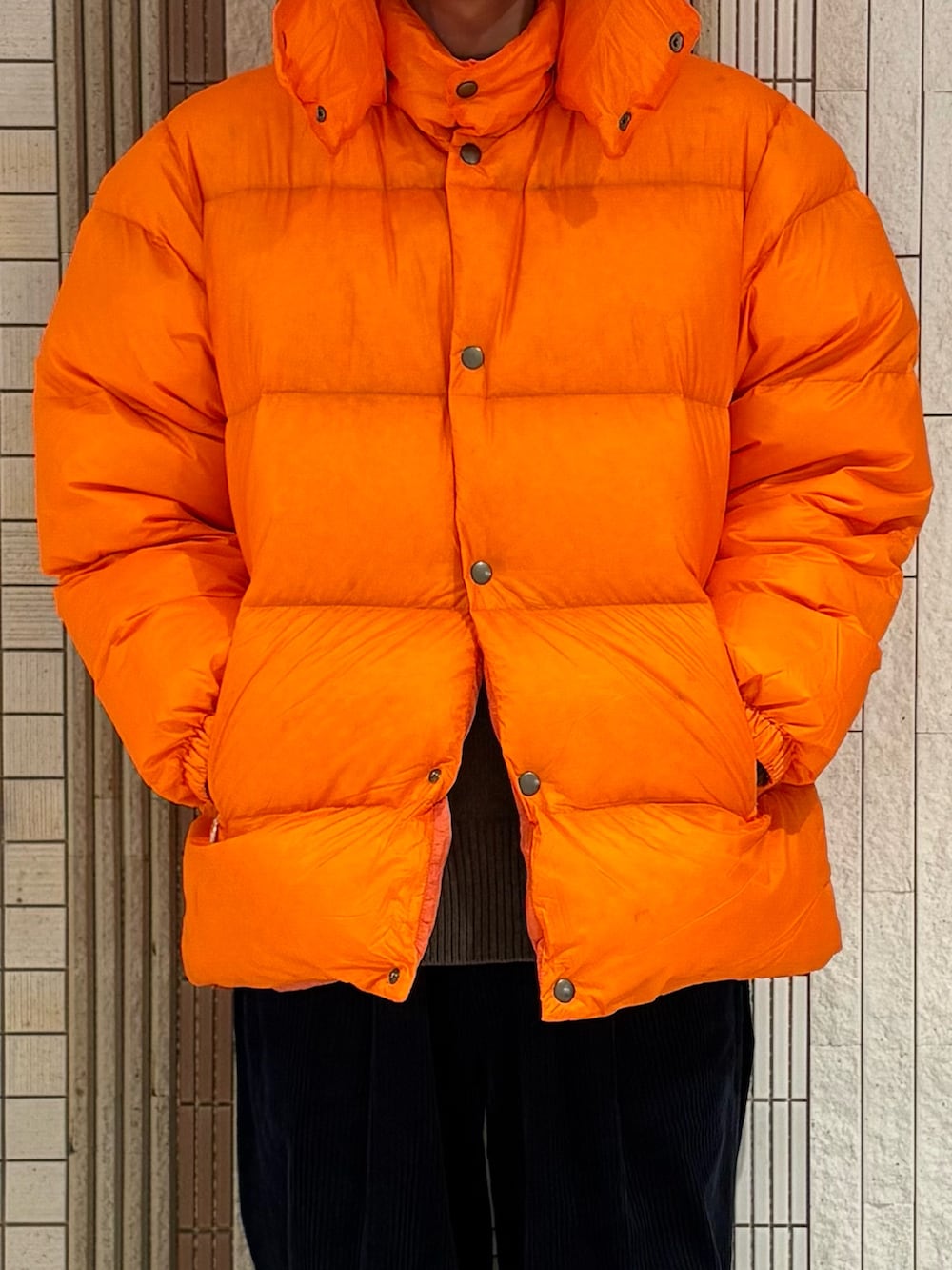 ブルー系のその他パンツ、ブルー系のスニーカー、オレンジ系のダウンジャケット/コートを着用したメンズの秋コーディネートの3枚目の写真