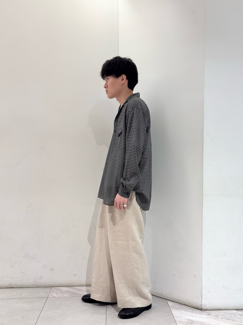 ブラック系のシャツ/ブラウス、ベージュ系のその他パンツ、ブラック系のブーツを着用したメンズの春コーディネートの4枚目の写真