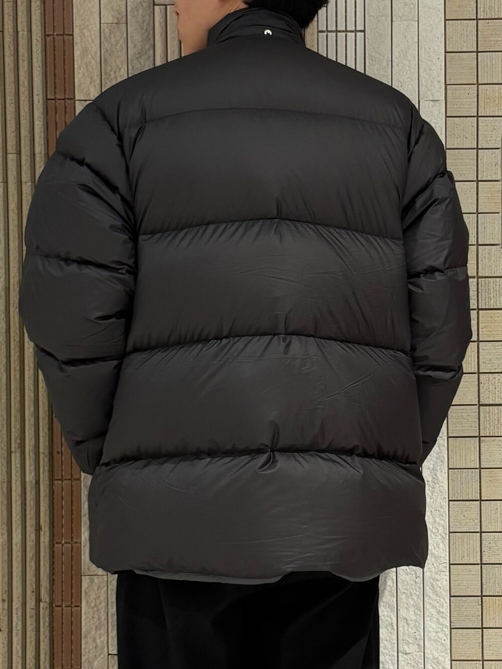 グリーン系のダウンジャケット/コート、グレー系のニット/セーターを着用したメンズの冬コーディネートの7枚目の写真