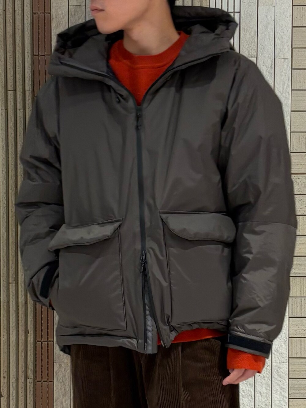 グレー系のダウンジャケット/コート、レッド系のニット/セーター、ブラウン系のその他パンツを着用したメンズの秋コーディネートの3枚目の写真