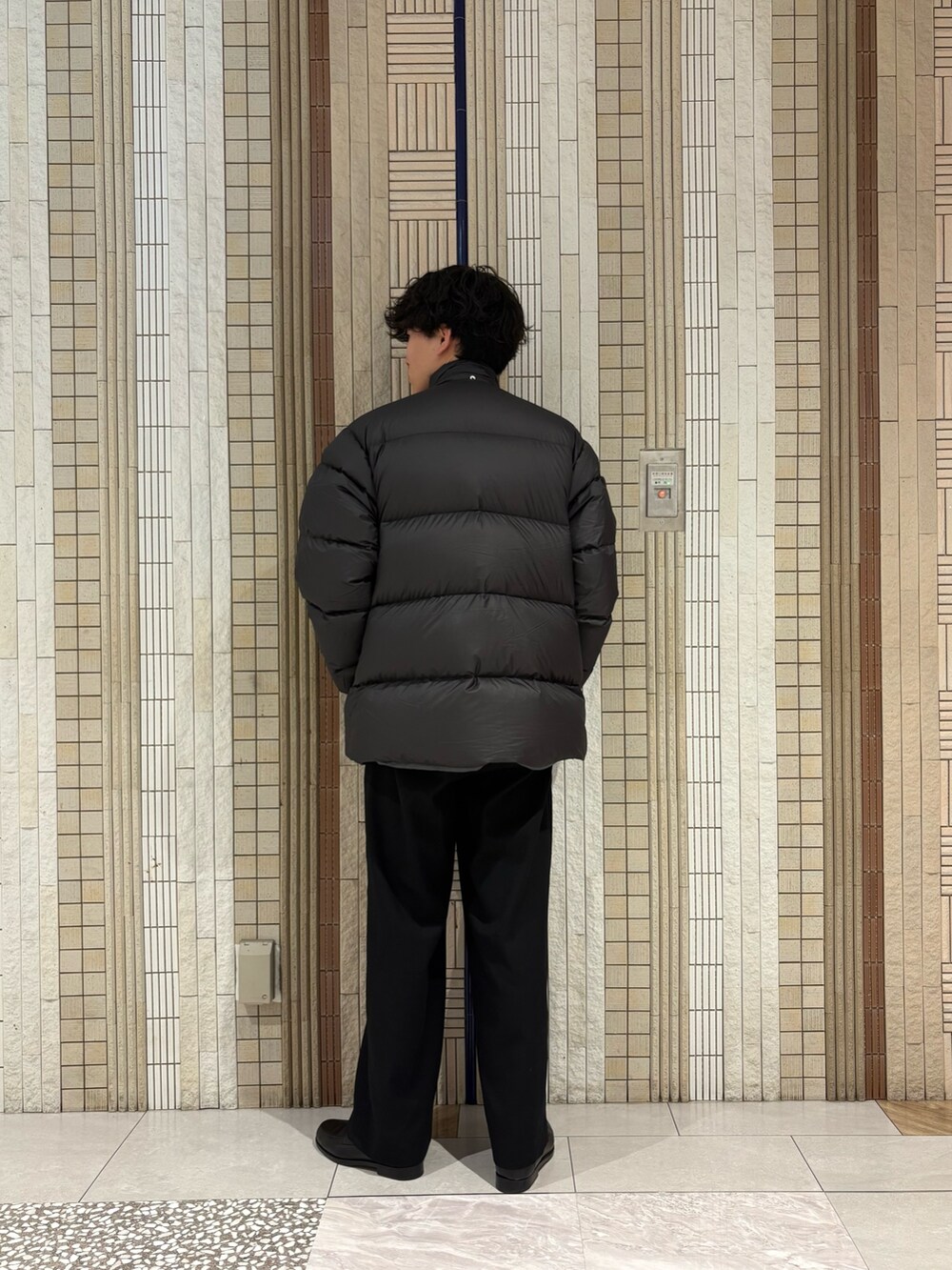 グリーン系のダウンジャケット/コート、グレー系のニット/セーターを着用したメンズの冬コーディネートの6枚目の写真