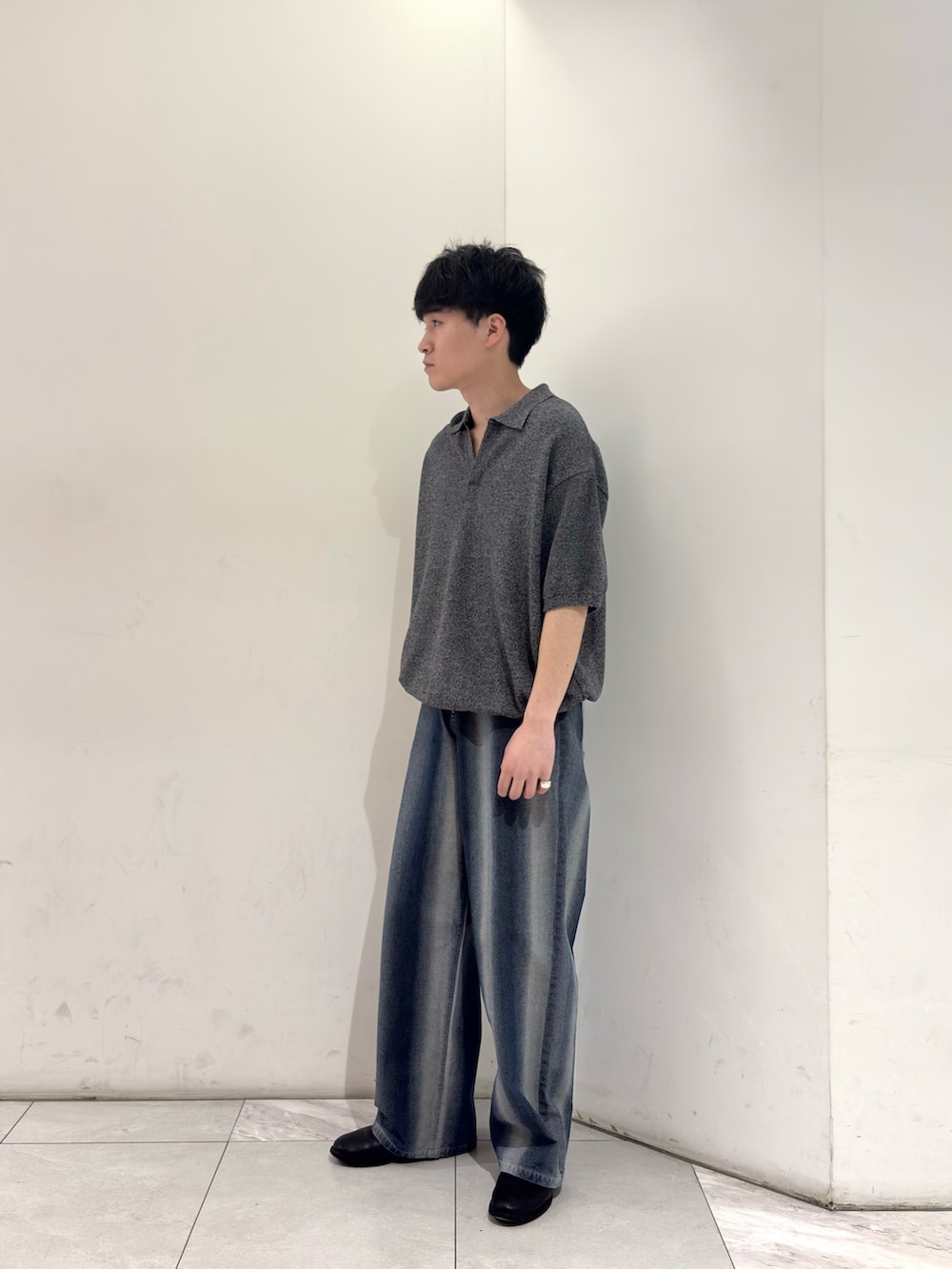 グレー系のニット/セーター、ブルー系のデニムパンツ、ブラック系のブーツを着用したメンズの春コーディネートの4枚目の写真