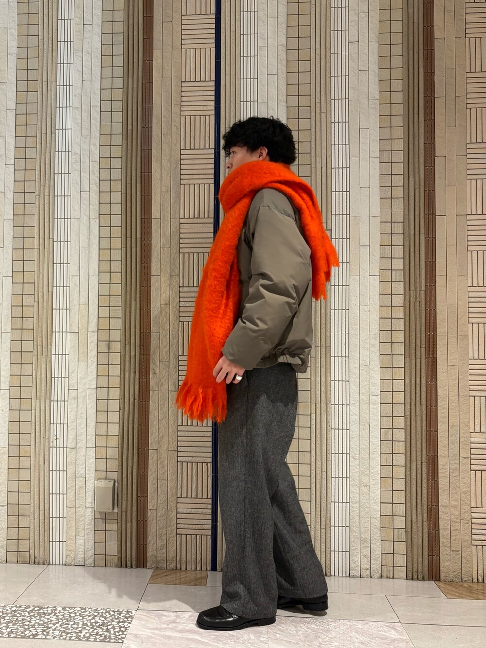 ベージュ系のダウンジャケット/コート、ブラウン系のニット/セーター、グレー系のその他パンツを着用したメンズの秋コーディネートの5枚目の写真