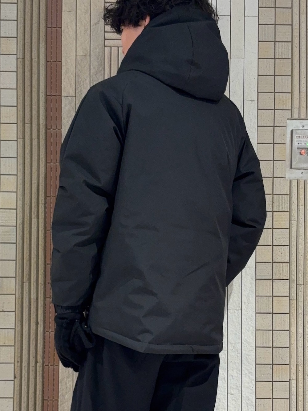 ブラック系のダウンジャケット/コート、ブラック系のニット/セーター、ブラウン系のその他パンツを着用したメンズの冬コーディネートの9枚目の写真