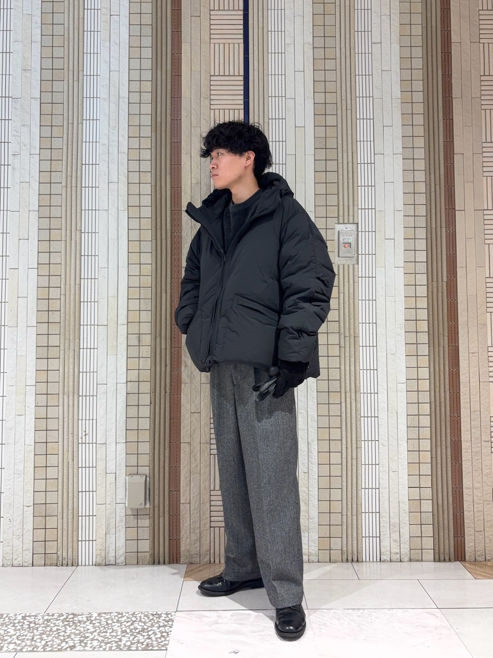 ブラック系のダッフルコート、グレー系のニット/セーター、グレー系のその他パンツを着用したメンズの冬コーディネートの2枚目の写真