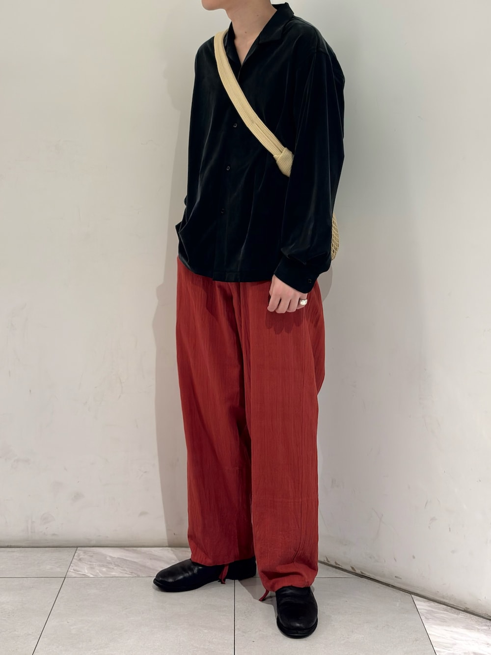 ブラック系のシャツ/ブラウス、ベージュ系のショルダーバッグ、ブラック系のブーツを着用したメンズの春コーディネートの2枚目の写真