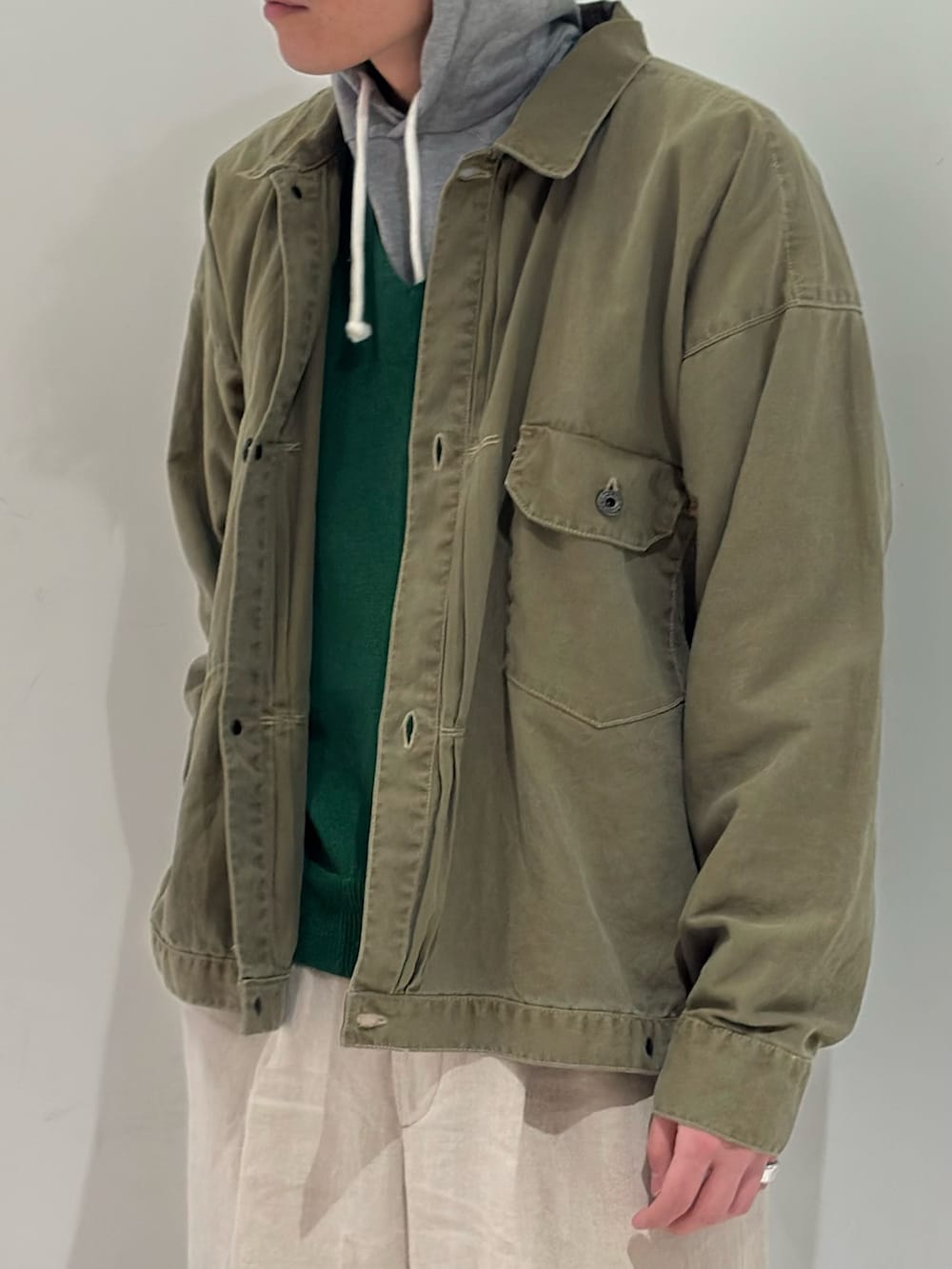 グリーン系のブルゾン、ブラック系のブーツを着用したメンズの春コーディネートの3枚目の写真