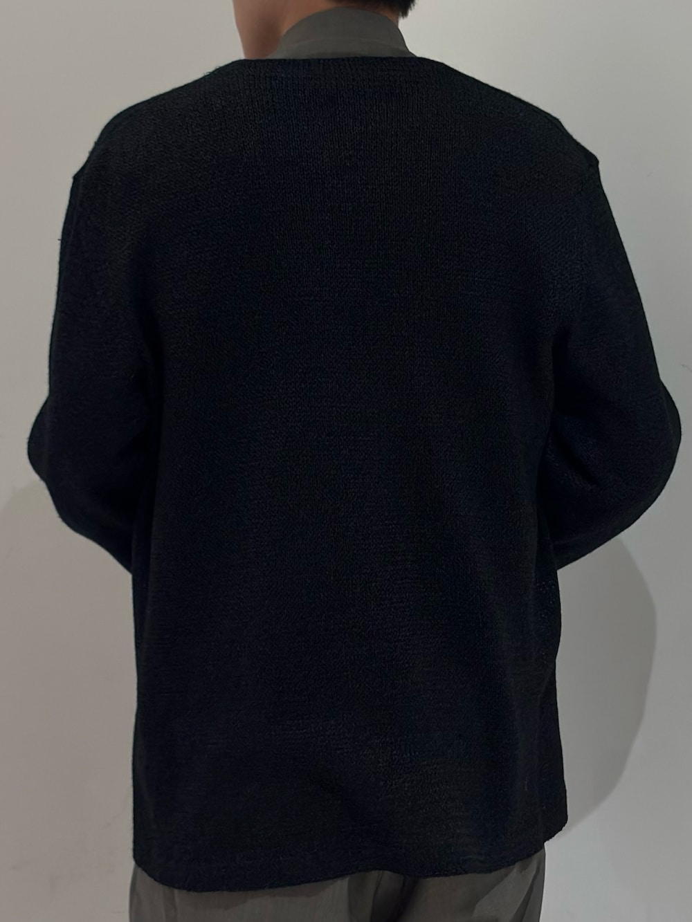 ブラック系のニット/セーター、ブラック系のベスト、グレー系のブルゾンを着用したメンズの春コーディネートの7枚目の写真